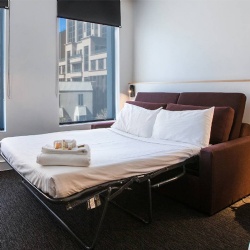 Sleeper sofa with pullout mattress in hotel room
