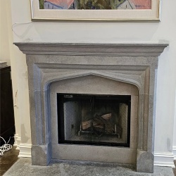 Stuart fireplace surround by gray limestone