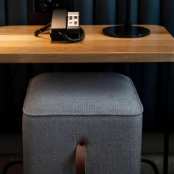 Upholstered ottoman with vinyl pull in Novotel hotel room
